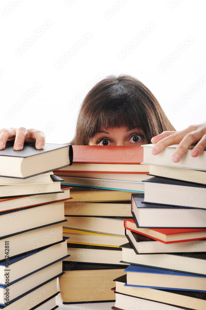 young woman behind a big pile of books