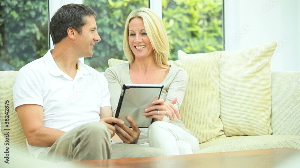 Modern Wireless Tablet Being Used by Caucasian Couple Modern Wireless Tablet Being Used by Caucasian Couple