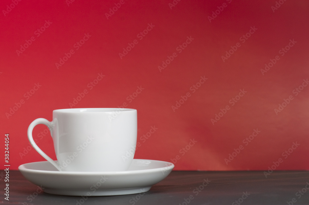 A white cup in front of red background