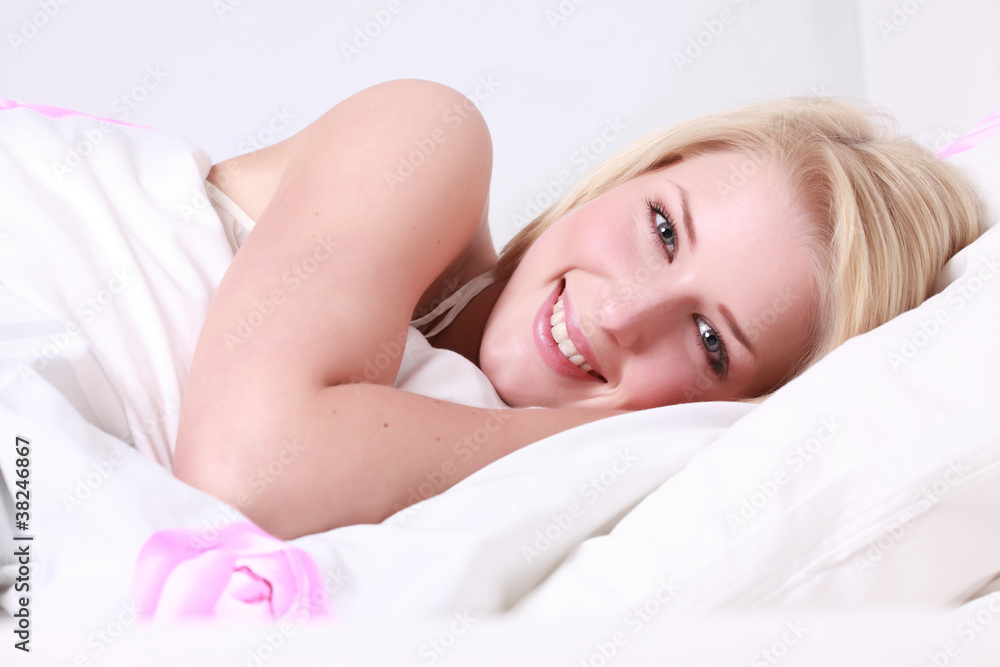 junge frau lachend im bett liegend junge frau lachend im bett liegend