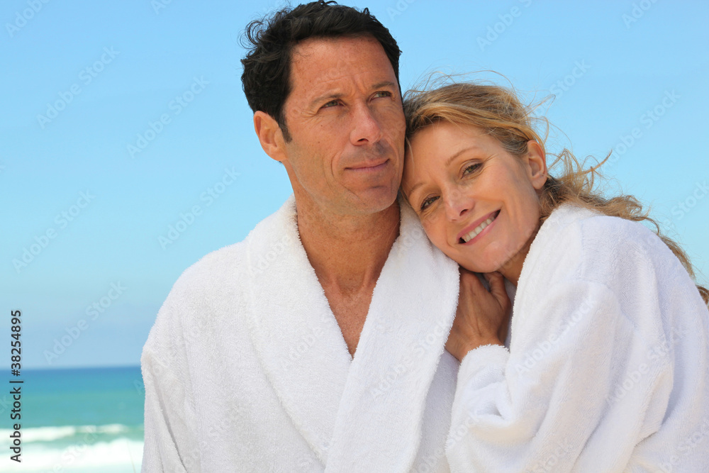 couple in robes on the beach