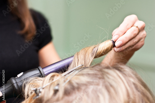Hairdresser to curl the hair in a beauty salon