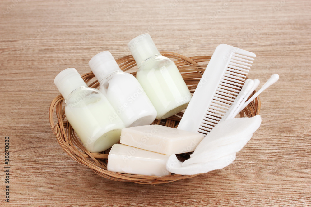 Obraz na plátně Hotel amenities kit in basket on wooden background