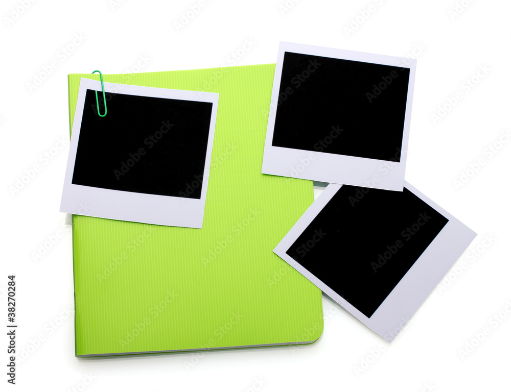 Photo papers and green notebook isolated on white Photo papers and green notebook isolated on white