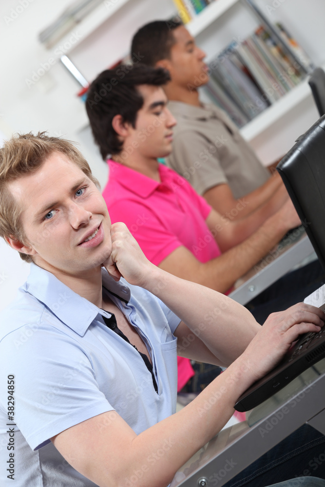 Fototapeta premium male students in class working on laptop