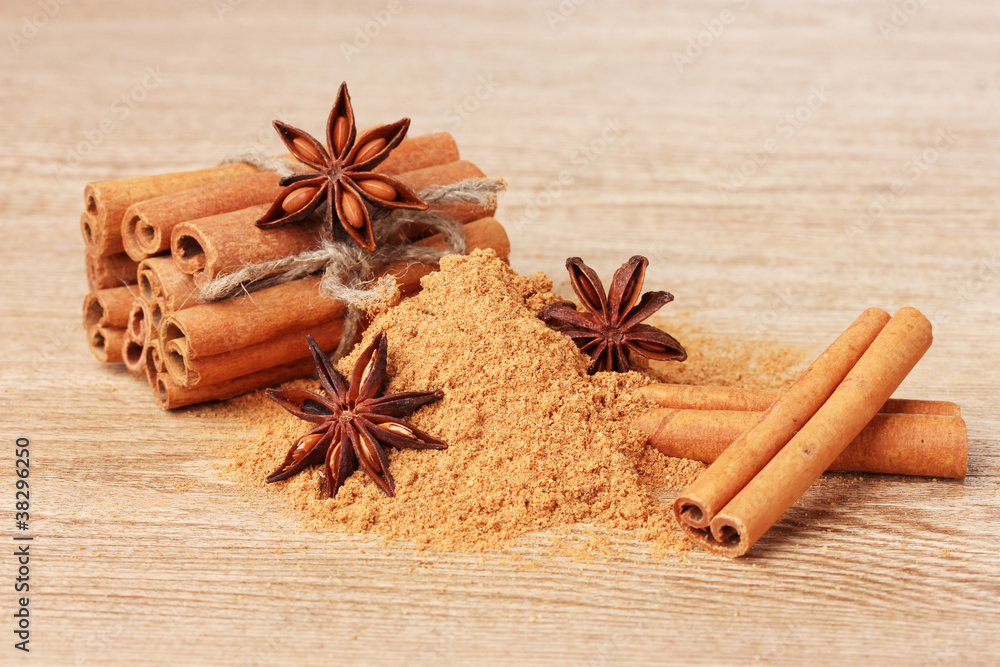 Cinnamon sticks, powder and anise on wooden table Cinnamon sticks, powder and anise on wooden table