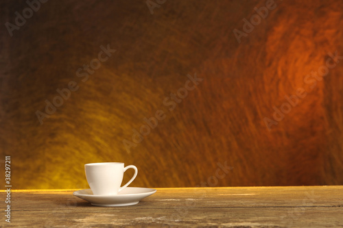 white coffee cup on wooden table, orange background