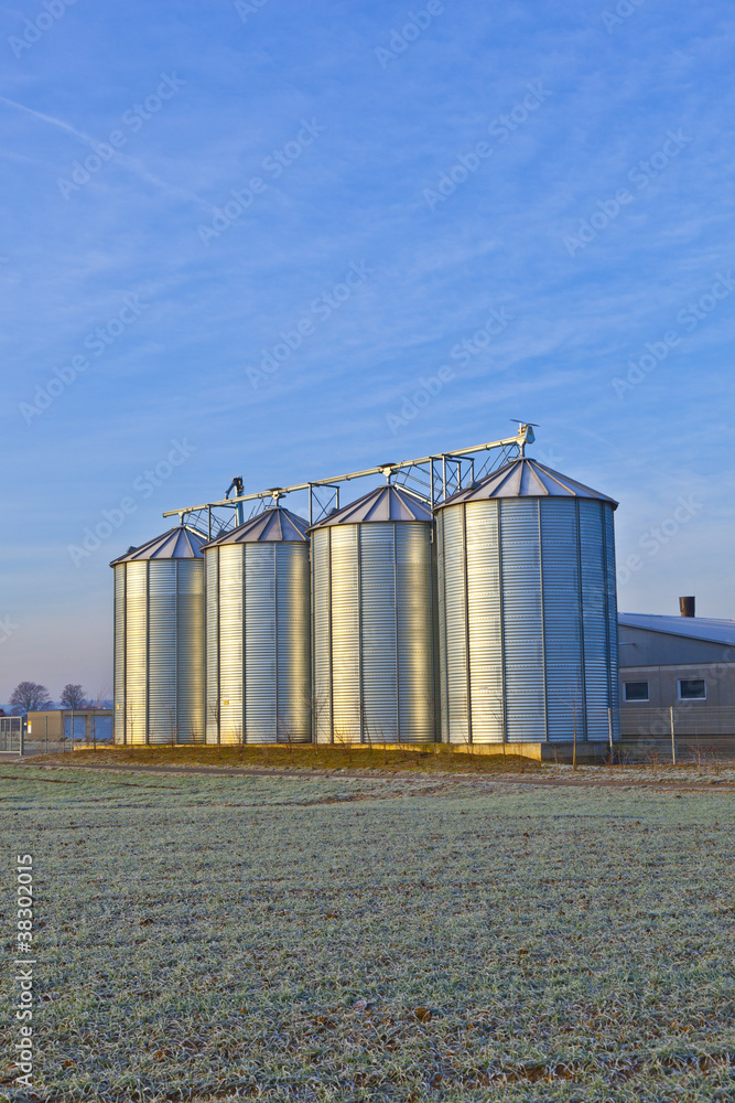 silos in the middle of a field in wintertime