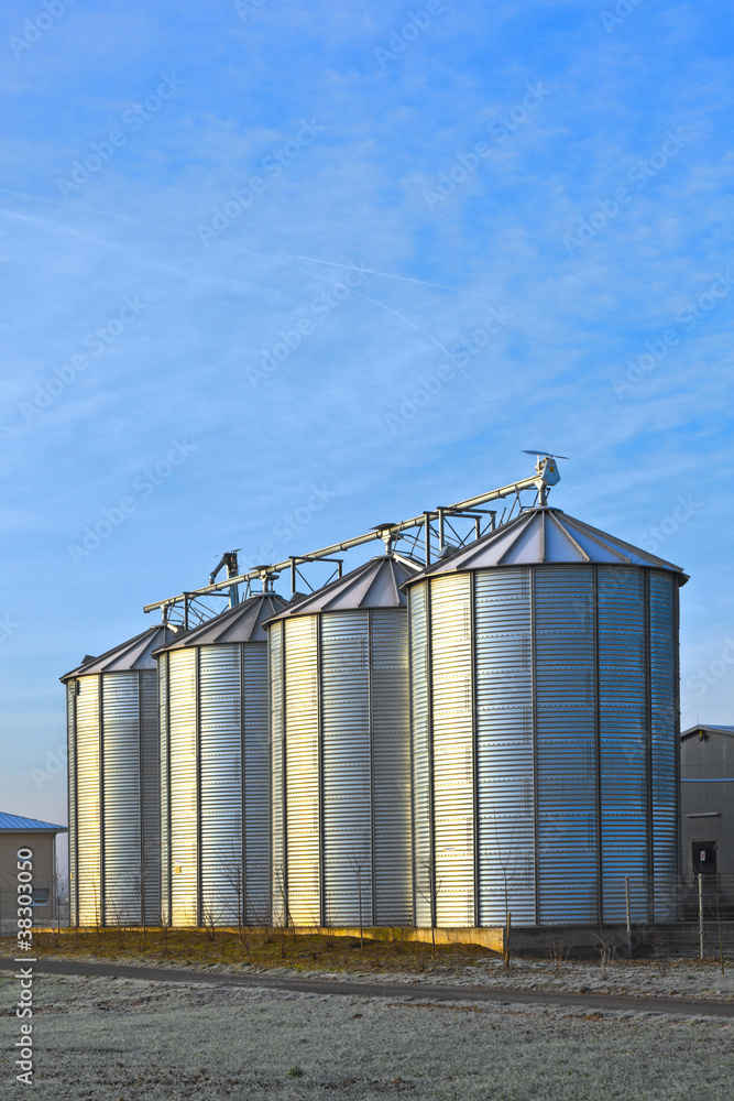 silos in the middle of a field in wintertime