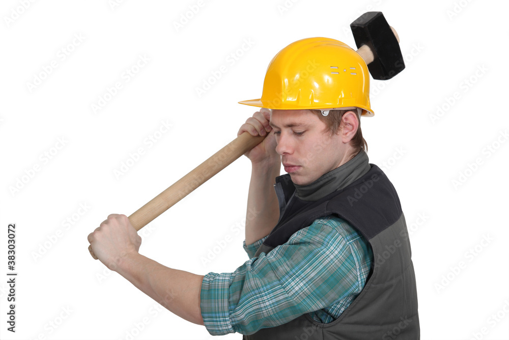 young craftsman working with a huge hammer young craftsman working with a huge hammer