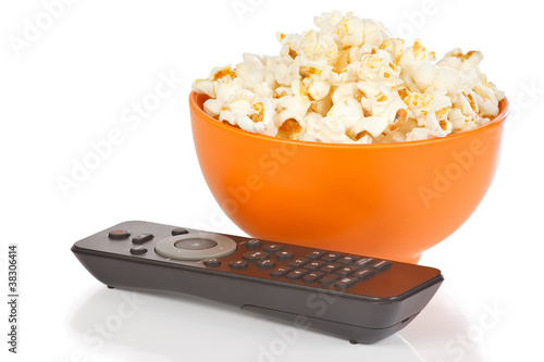 Popcorn in a orange bowl and remote control
