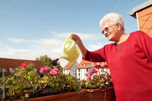 seniorin gießt Blumen