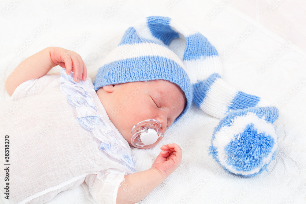 newborn baby sleeps in a knitted striped hat newborn baby sleeps in a knitted striped hat
