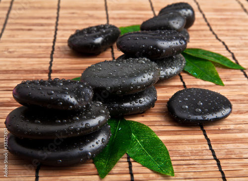 black stone with leaf. massage stones