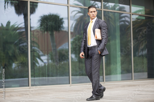 Businessman walking next to his office