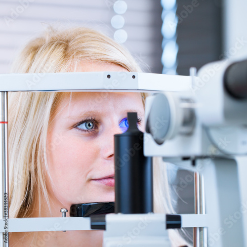 pretty, young female patient having her eyes examined