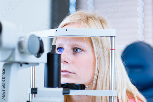 pretty, young female patient having her eyes examined