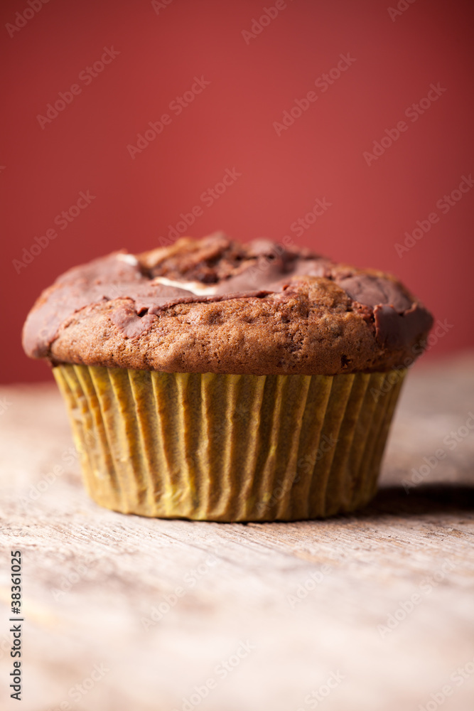 einzelner Muffin auf rotem Hintergrund einzelner Muffin auf rotem Hintergrund