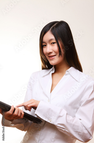 junge asiatin im weißen hemd mit touchpad photo