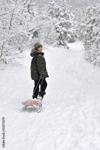 boy walking with sleds