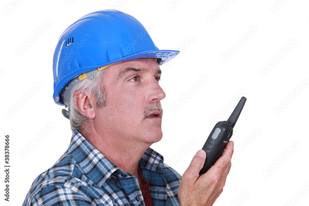 A foreman talking on a walkie-talkie. A foreman talking on a walkie-talkie.