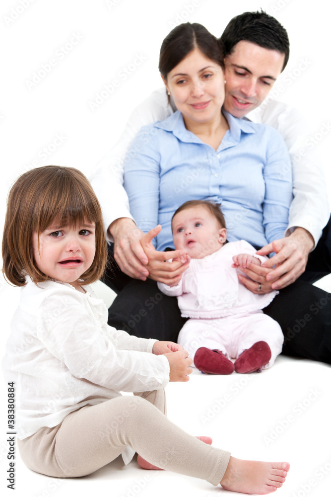 Unhappy jealous little girl with family