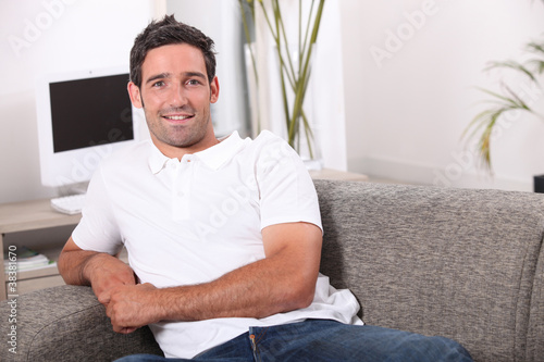 35 years old man sitting in a comfortable couch photo