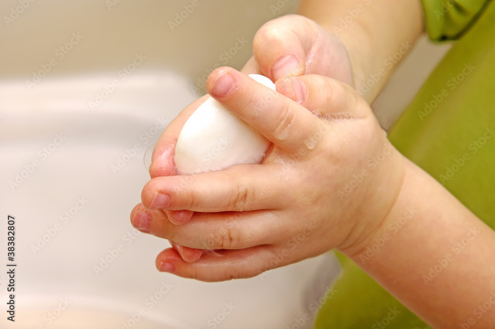 Naklejka premium Boy washes with running water and soap hands