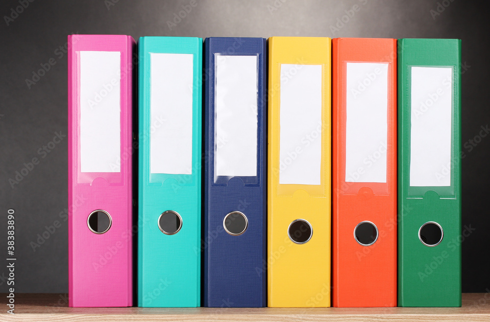 bright office folders on wooden table on grey background bright office folders on wooden table on grey background