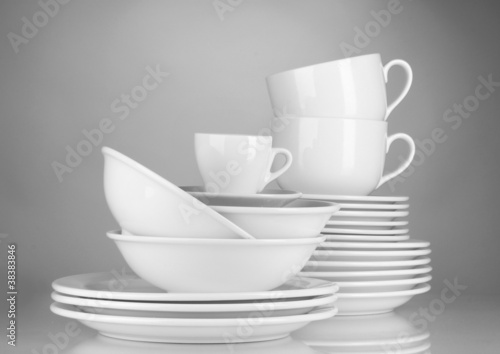 empty bowls, plates and cups on gray background