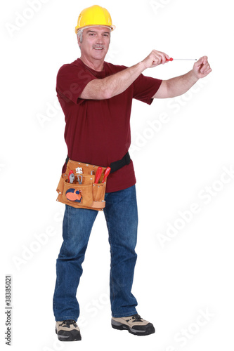 Construction worker using a screwdriver in empty copyspace