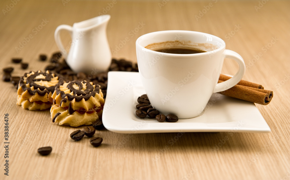 Cup of coffee with beans and cinnamon sticks Cup of coffee with beans and cinnamon sticks