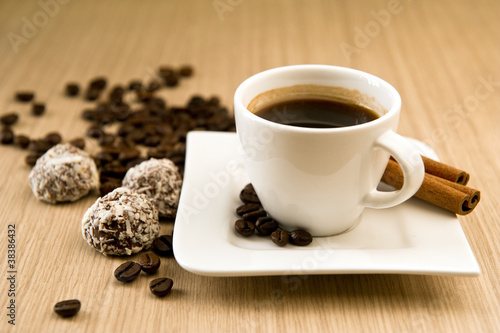 Cup of coffee with beans and truffles