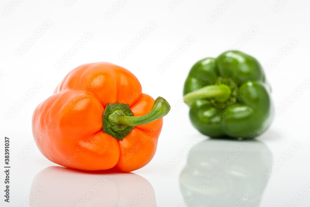 orange und grüne Paprika freigestellt vor weissem Hintergrund orange und grüne Paprika freigestellt vor weissem Hintergrund