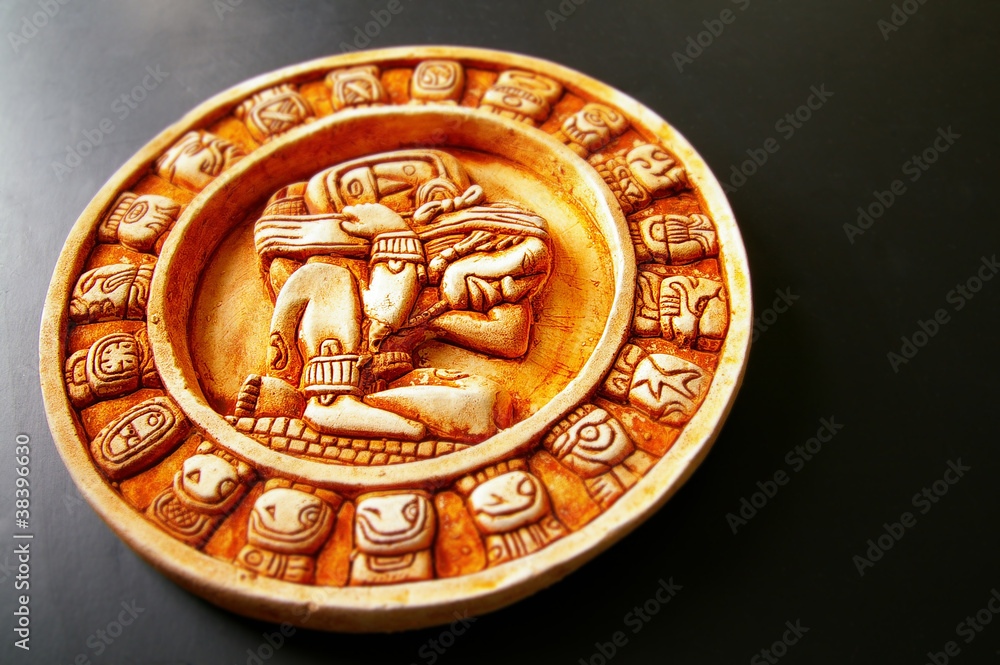 A carved Mayan calendar on dark background A carved Mayan calendar on dark background