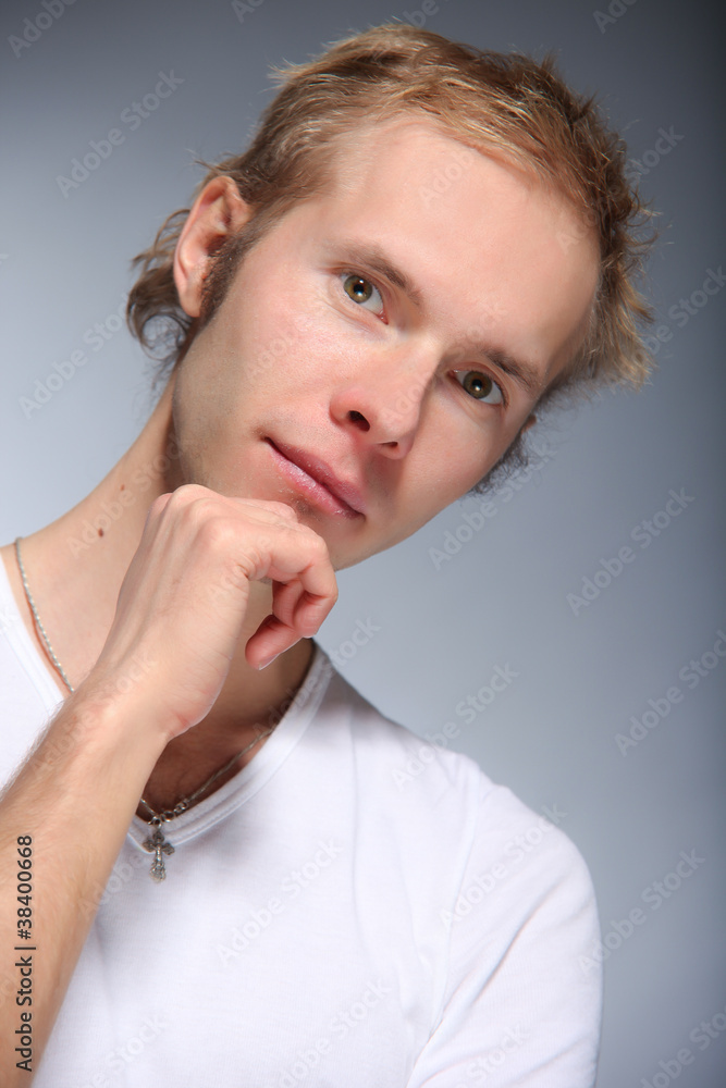 Pretty young man posing on light background Pretty young man posing on light background