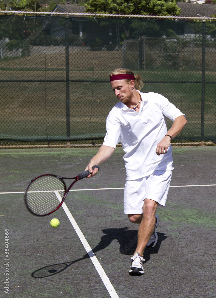 Male tennis player makes a forehand swing