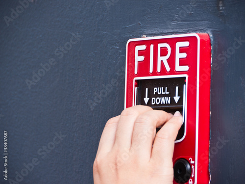 Hand on fire alarm box