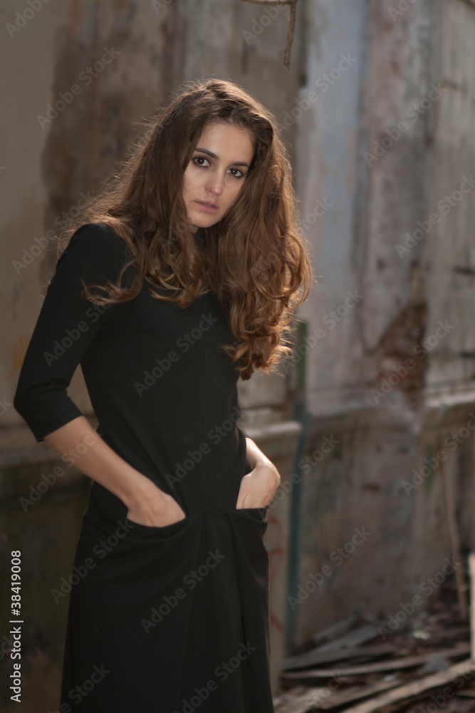 Portrait of young lonely woman thrusting hands into pockets