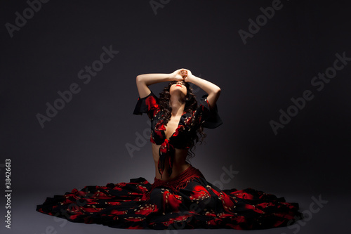 young woman sit in gypsy black and red costume