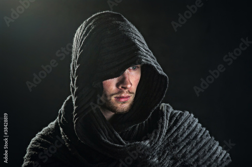 A bearded man in a hood.