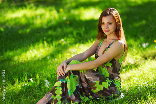 brunette sitting on green grass