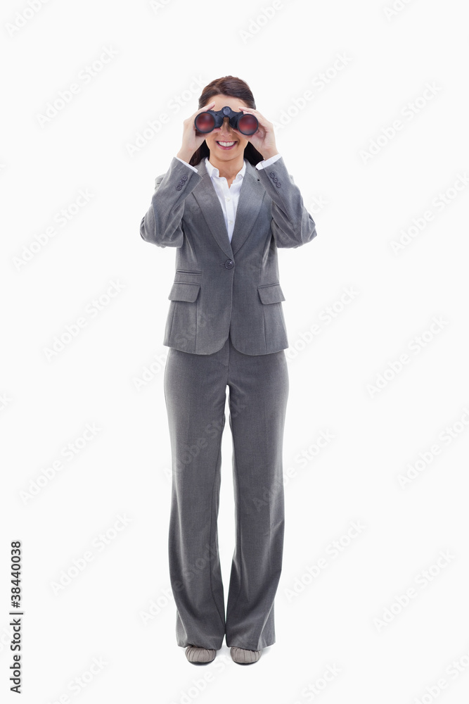 Businesswoman smiling and looking through binoculars Businesswoman smiling and looking through binoculars