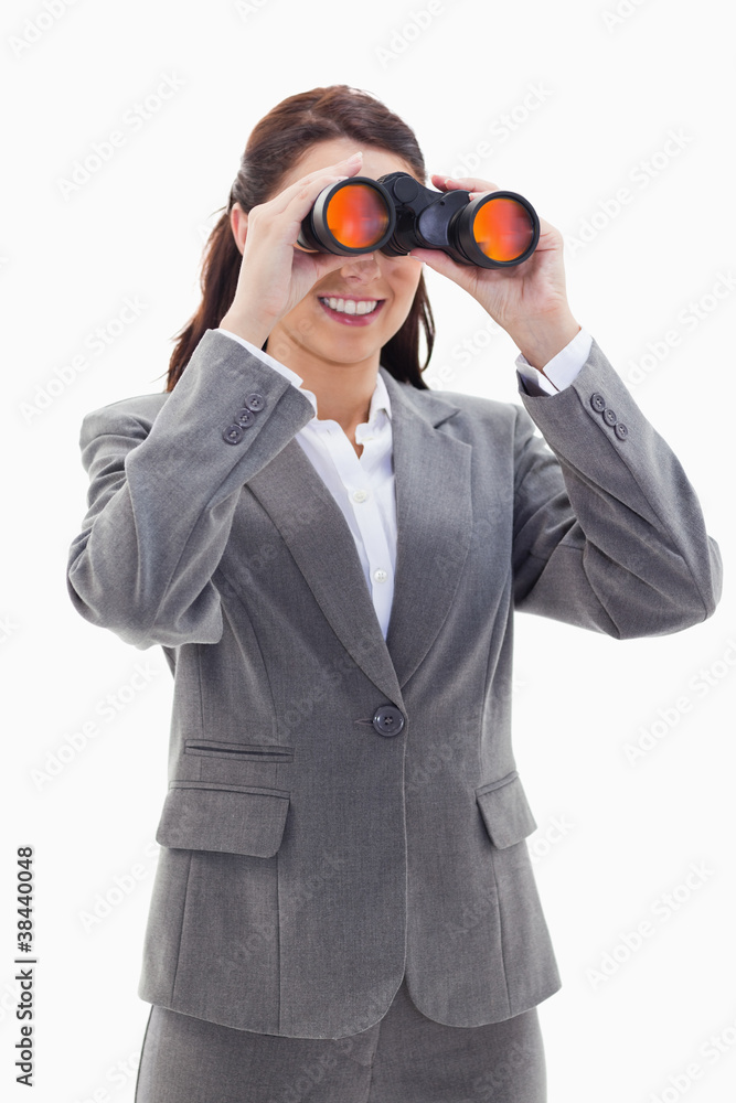 Close-up of a businesswoman smiling and looking through binocula Close-up of a businesswoman smiling and looking through binocula