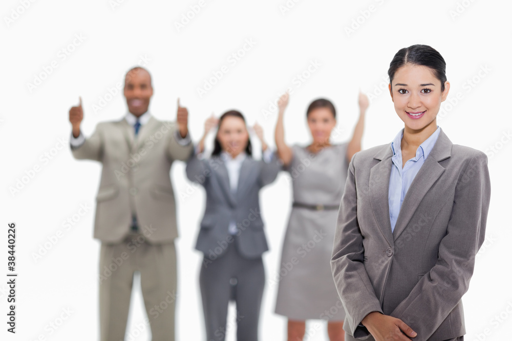 Businesswoman smiling with co-workers approving in the backgroun Businesswoman smiling with co-workers approving in the backgroun