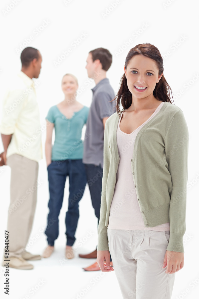 Woman smiling with her friends chatting behind Woman smiling with her friends chatting behind