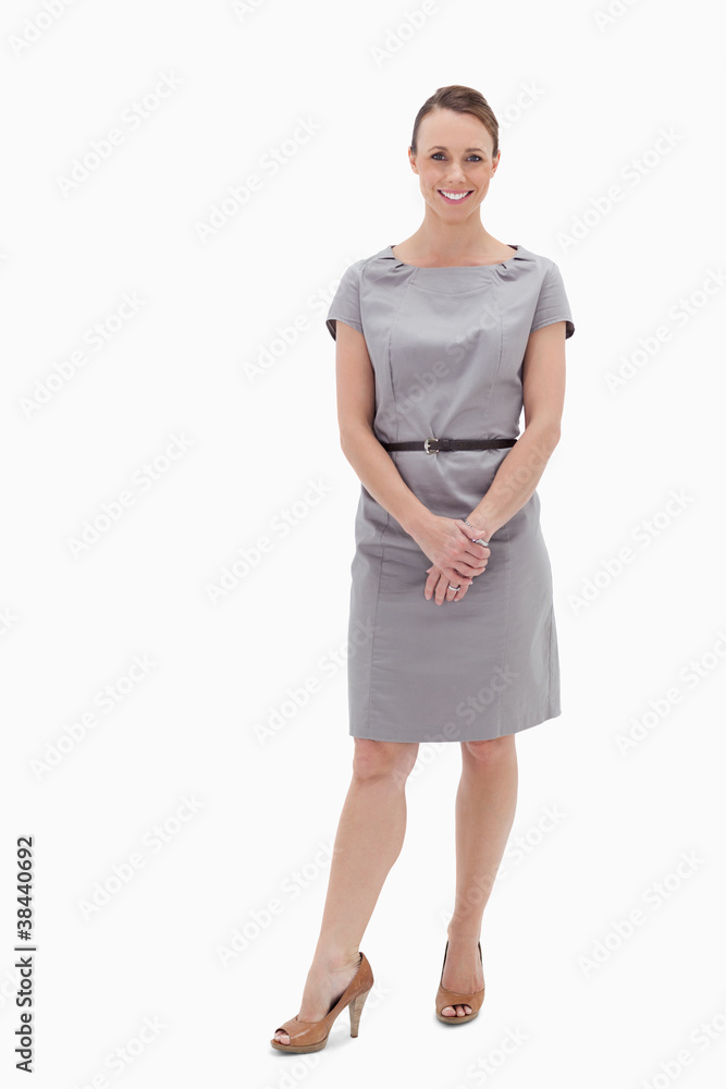 Smiling woman standing up and holding her hands Smiling woman standing up and holding her hands