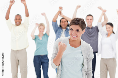 Woman clenching her fist with people behind raising their arms