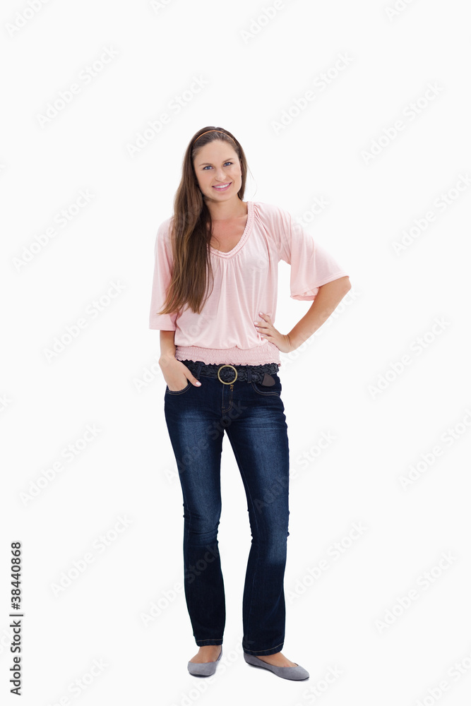 Woman smiling with her hand on her hip and the other hand in her Woman smiling with her hand on her hip and the other hand in her