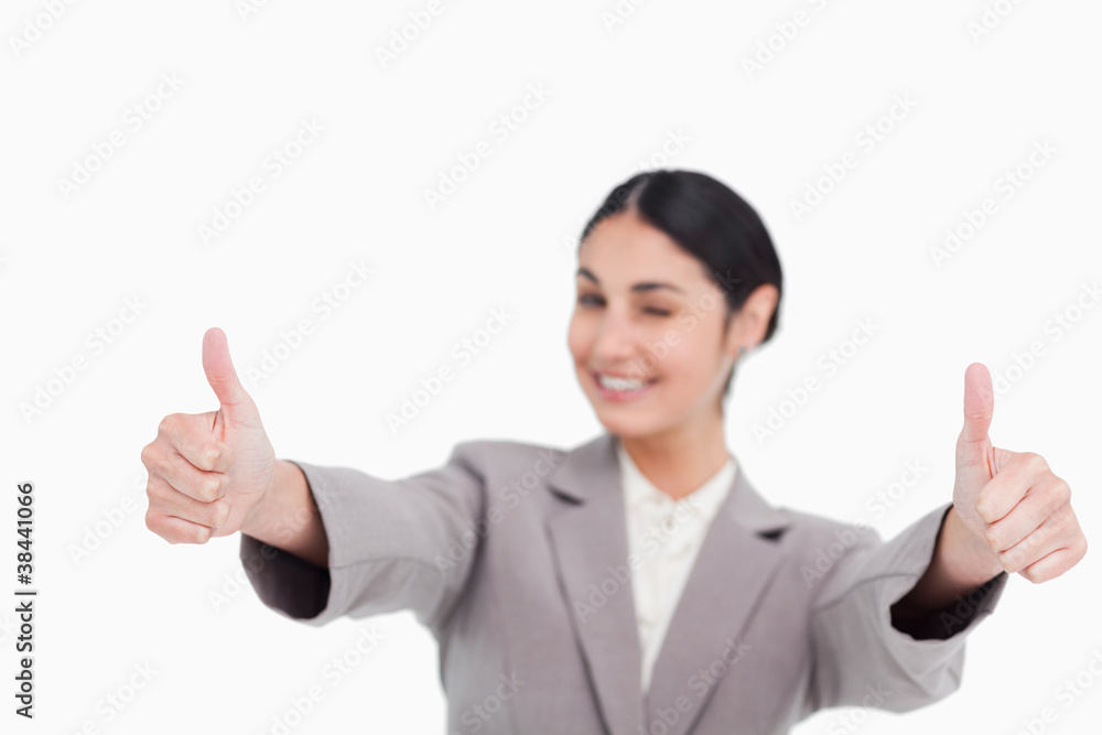 Thumbs up given by smiling young businesswoman Thumbs up given by smiling young businesswoman